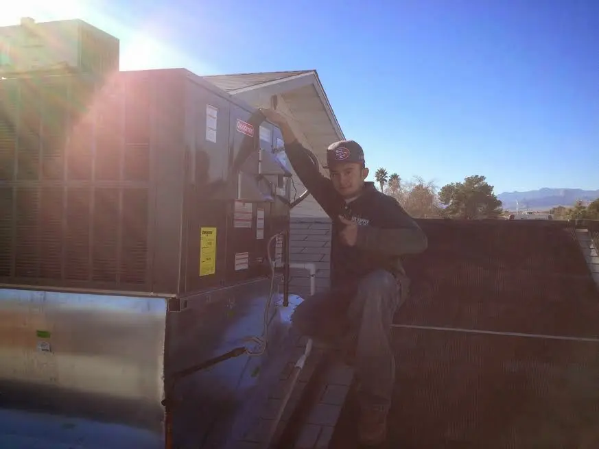 HVAC technician performing AC Tune-Up on a rooftop unit in Lovington